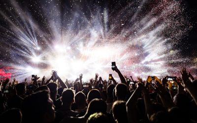 Excited audience watching confetti fireworks and having fun on music festival at night. Copy space.